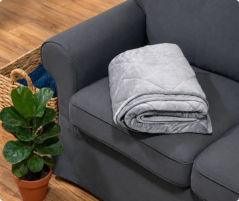 Velin Weighted Blanket folded on a grey sofa