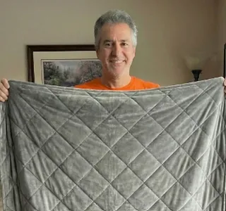 Customer holding up the Velin Weighted Blanket at home